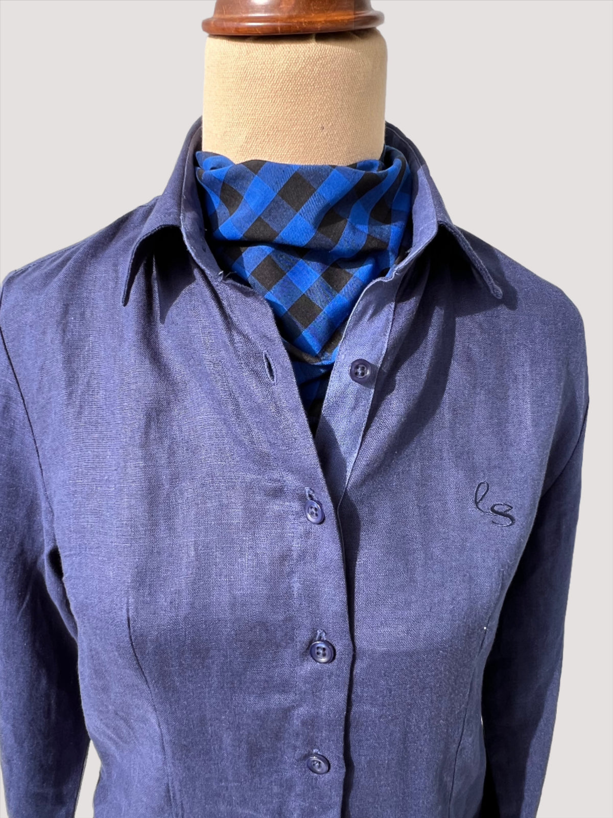 Blue and black check neck scarf featured on dress form with navy linen shirt